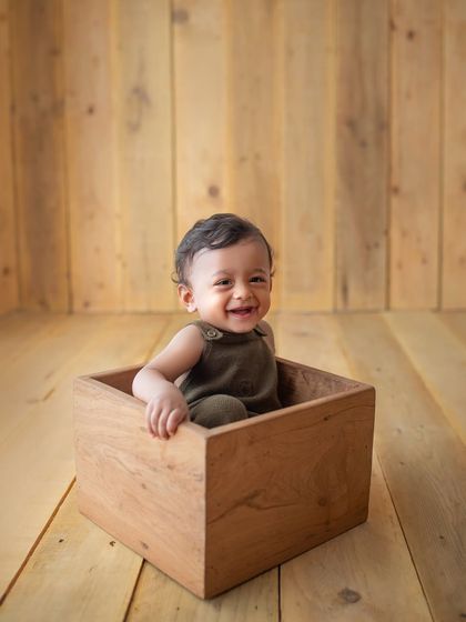 That gummy smile is everything! This little guy was having so much fun playing with the wooden blocks during his sitter session.