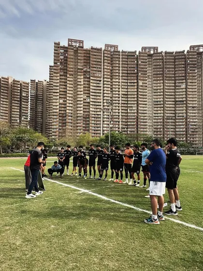 Our senior team gathered around the coaches for a tactical briefing against the backdrop of Noida's skyline. We believe in having an absolute sense of mission.