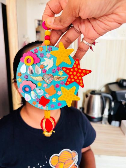 My daughter peeking from behind the "Our Angels" hanging. It's a piece that represents love and family.