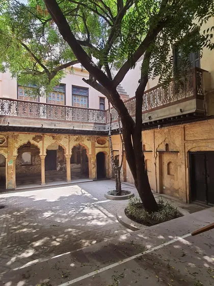 A view of the courtyard before it was bustling with life, showing the restored architectural details and the central tree that defines the space.