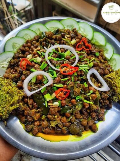 A plate of Kelichana with a piece of Paknam. The spicy chickpeas are a classic Manipuri snack.