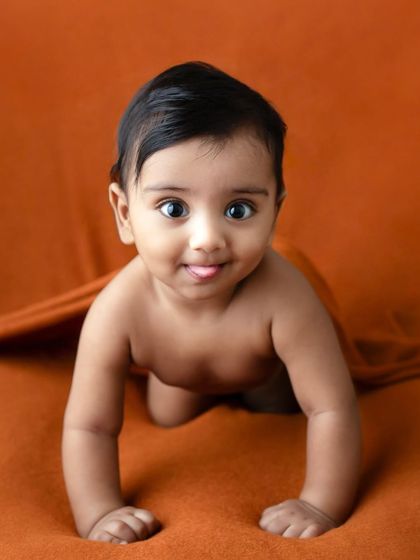 A six-month-old baby showing off their crawling skills. The simple setup allows their natural movement and joyful expression to be the star of the show.