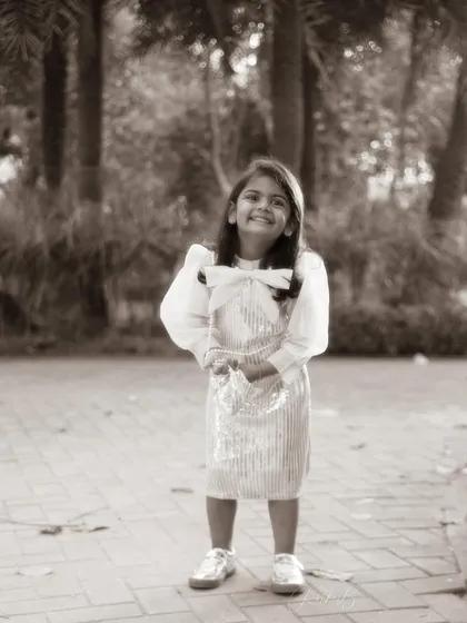 A classic black and white portrait in the park. Her sweet smile and confident pose show her personality shining through, even in a quiet moment.