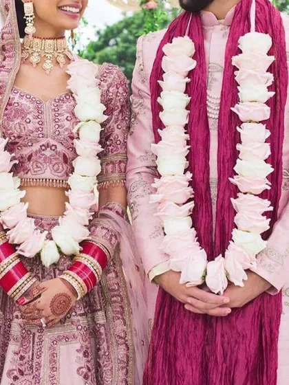 This elegant jaimala combines large white roses with delicate pink buds. It's a perfect example of a custom varmala designed to complement the couple's pastel pink wedding outfits.