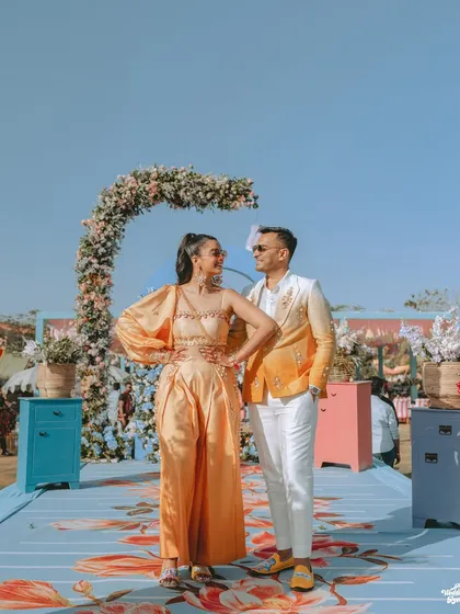 A full-length shot of the couple at their vibrant, sunny carnival event in Pushkar.