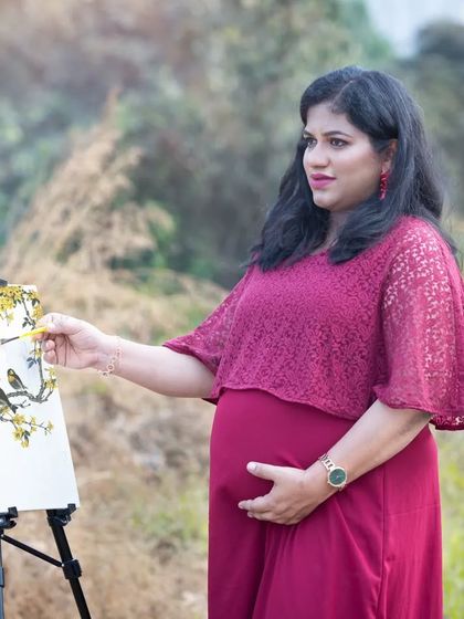 A creative and artistic maternity portrait. The mom-to-be is captured as if painting a masterpiece, symbolizing the beautiful life she is creating.