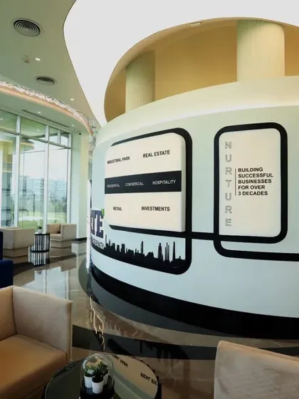 A detailed view of the central branding pillar in the corporate lounge. This element serves as a focal point, communicating the company's core values through a blend of graphics and architectural form.