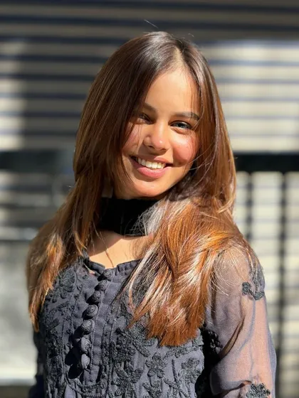 The smile says it all. This expertly colored and styled hair catches the light beautifully, showcasing the different tones and the healthy condition of the hair.