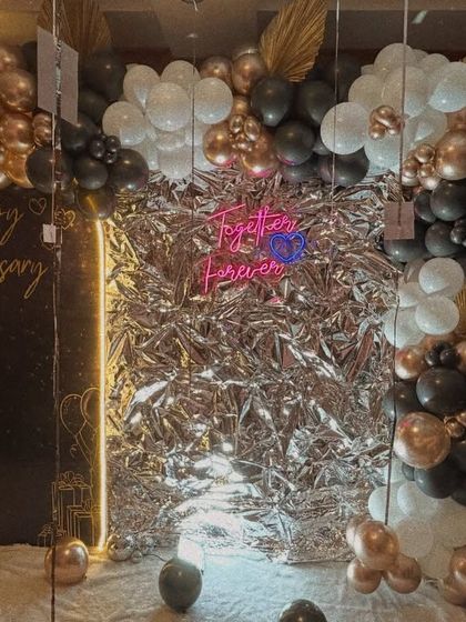 A full view of the shimmering anniversary decor, showing how the foil backdrop catches the light to create a dazzling effect.