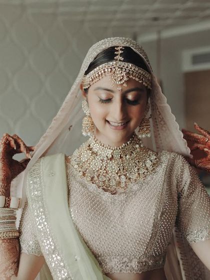 A happy, smiling portrait of the bride getting ready. This shot captures the joy and excitement of the wedding morning, as she adjusts her beautiful jewelry.