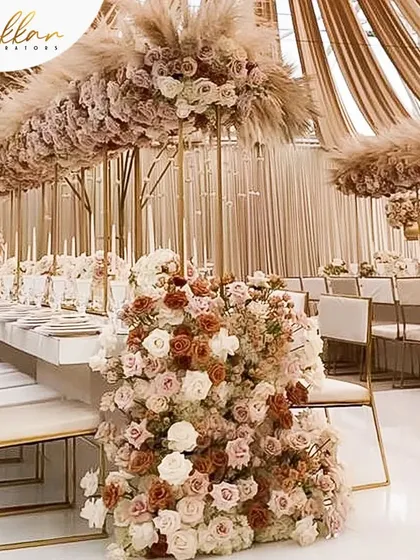 A monochrome dining setup for a reception, featuring shades of coffee and brown. The tables are adorned with massive floral centerpieces and pampas grass, creating a unique and sophisticated look.