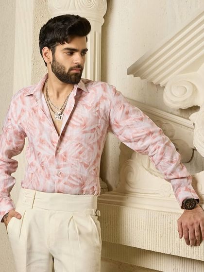 The details matter. This close-up shows the fine texture of the pink linen shirt and the way it drapes, highlighting the quality of the material and craftsmanship.