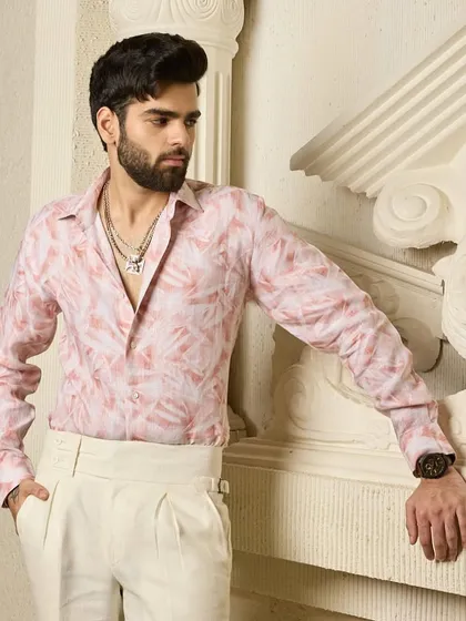 The details matter. This close-up shows the fine texture of the pink linen shirt and the way it drapes, highlighting the quality of the material and craftsmanship.