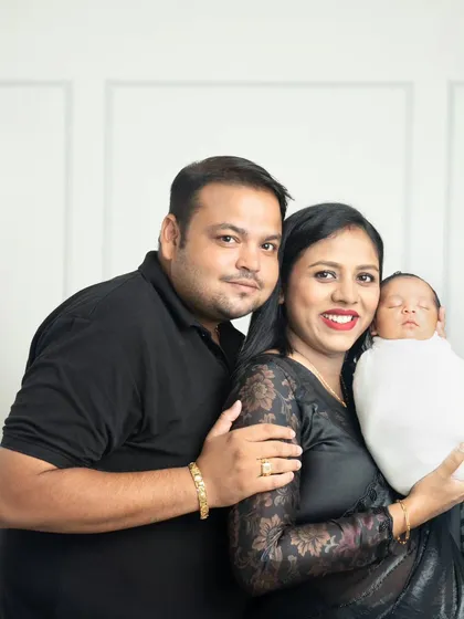 A classic newborn family portrait. The new parents hold their baby close, a beautiful and timeless photograph to mark this incredible milestone.