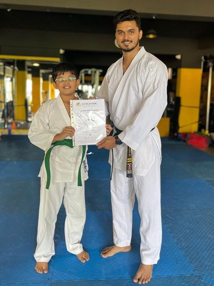 This young karateka is happy to receive his certificate after a successful belt test.