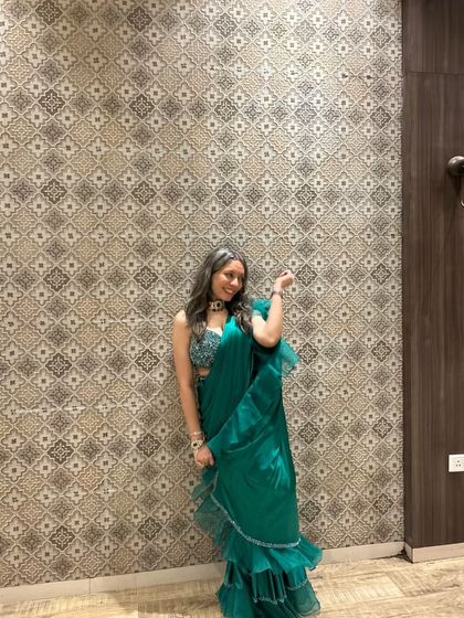 A full view of the green pre-stitched saree, perfect for a cocktail event or sangeet.