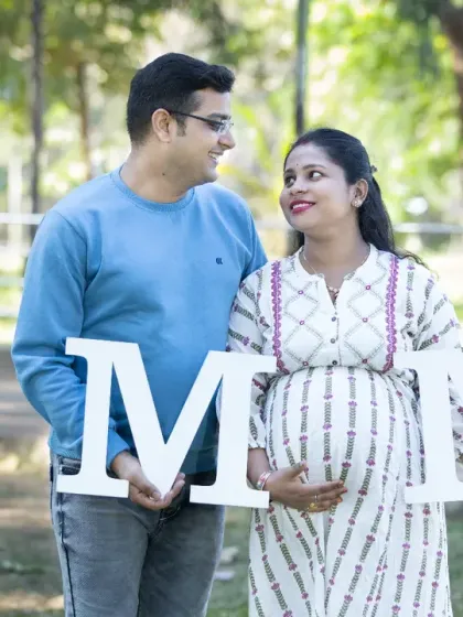 The shared look between two people about to become three. This candid shot with "MOM" letters captures the quiet understanding and excitement of the parents-to-be.