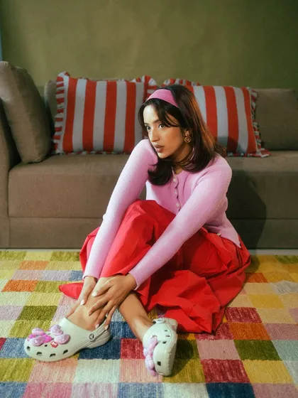 A relaxed, seated pose for a Crocs campaign. This image showcases the shoes in a casual, comfortable context, highlighting their versatility for everyday wear.