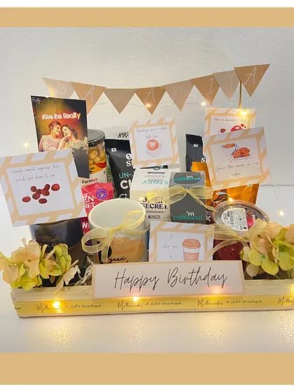 For the coffee aficionado, this birthday hamper is a dream. It's packed with different types of coffee, cookies, and a personalized 'Happy Birthday' banner, all illuminated with fairy lights.