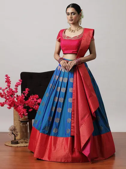 A striking blue and red half-saree lehenga, featuring silver buti work on the skirt and a rich red Banarasi border.
