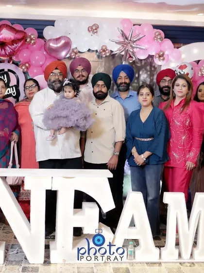 The entire family gathers for a group photograph at a first birthday celebration in Delhi. I am experienced in organizing and shooting large group portraits during busy events.