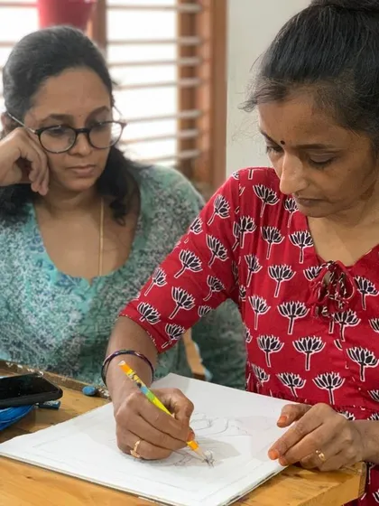 An instructor provides feedback on a student's mandala drawing. This collaborative process ensures that every artist feels supported and guided on their journey.