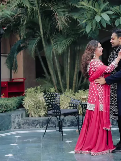 A romantic, full-length portrait of the couple sharing a look during their Roka ceremony. The outdoor setting adds a natural and relaxed feel to the photograph.