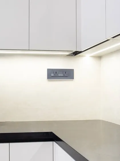 The matte black faucet and sink are a sophisticated touch against the white and black palette. This close-up also shows the subtle texture of the backsplash, which adds another layer of detail to the space.