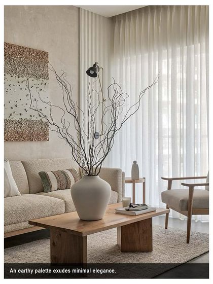An earthy palette exudes minimal elegance in this living room. The focus is on creating a pleasant seating zone with a white boucle fabric sofa and a grey and white striped armchair.