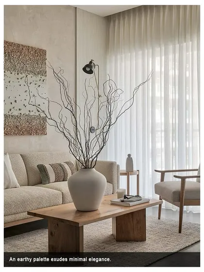 An earthy palette exudes minimal elegance in this living room. The focus is on creating a pleasant seating zone with a white boucle fabric sofa and a grey and white striped armchair.