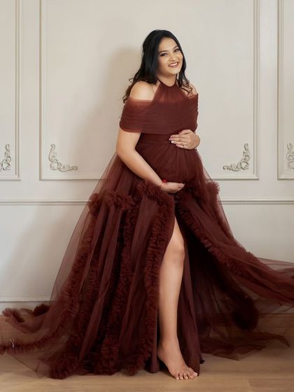 A full-length shot of our Renee gown. The halter-style neckline and ruffled trail create a unique and elegant look.