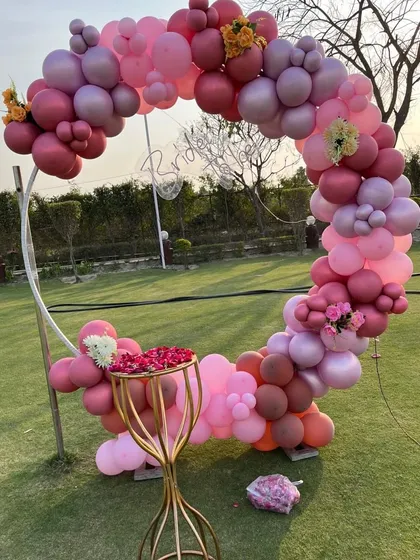 For this outdoor 'Bride to be' party, I created an elegant photo booth using a circular frame decorated with a full arch of pink and mauve balloons. Set up on a lawn, it becomes a beautiful focal point for photos and adds a touch of modern style to the celebration.
