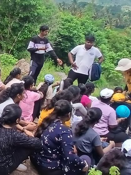 Instructors engage with a group of students, answering questions and providing guidance during a break at the Ramanagara camp.