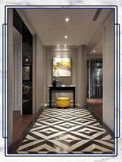 This hallway design uses a bold, black-and-white geometric floor pattern to create a strong visual statement. It's paired with simple wall panels and a minimalist console table for a balanced, modern look.