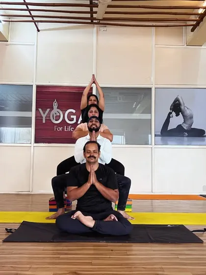 A group of students creating a multi-level yoga formation. This demonstrates the strength, balance, and trust that we cultivate in our advanced classes.