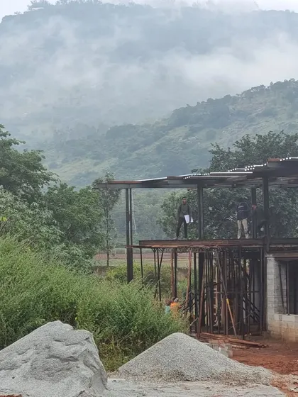 The mood at the site on a rainy day, with the hills disappearing into the clouds. The process of building is often a dance with the elements, a patient waiting for concrete to arrive while the landscape puts on a show.