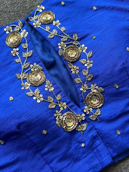 A detailed close-up of the sequin and embroidery work on the blue blouse.