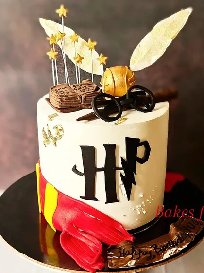 Another fantastic Harry Potter cake, this one featuring the HP logo, a Gryffindor scarf, and Harry's iconic glasses. The golden snitch and stars add a magical touch.