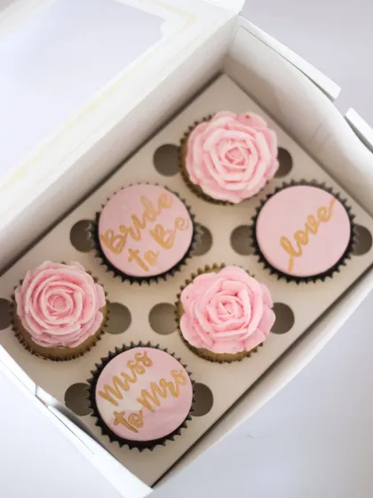 Custom cupcakes make the cutest gifts! This box was for a bridal shower, with hand-painted messages like "Bride to Be" and "Miss to Mrs" alongside piped buttercream roses. They are perfect for bridesmaid proposals and bachelorette parties.