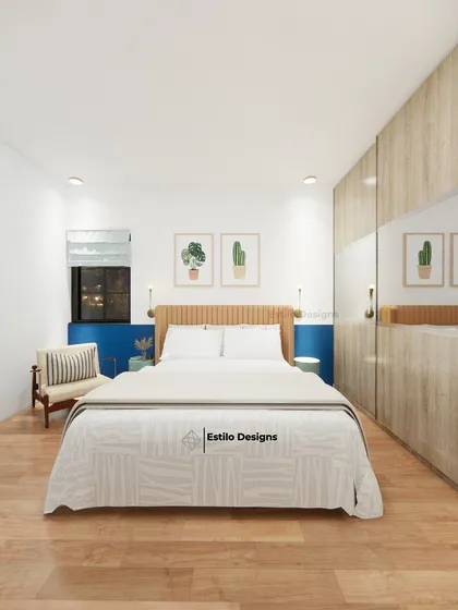 This guest bedroom is an exercise in minimalism, designed to be simple and functional. The room features a light wood wardrobe with mirrored panels to enhance the sense of space, complemented by a pop of blue on the accent wall.