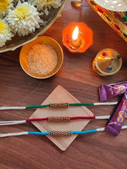A set of simple and elegant rakhis made with thread and golden beads. These are available in green, red, and blue.