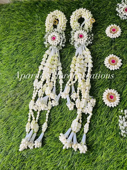 A pair of beautifully crafted bajuband with delicate tassels, made from fresh white flower buds and accented with pink gems.