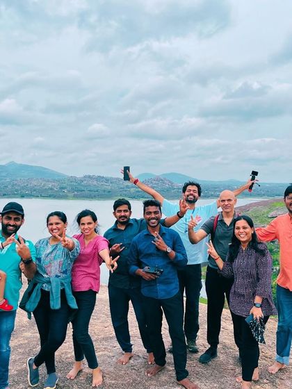 All smiles at Huthridurga, with the lake in the background. This trek provides stunning views and a great sense of accomplishment.