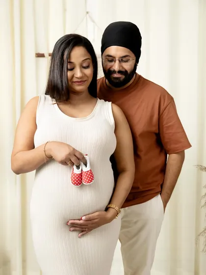 Sometimes the smallest things tell the biggest story. Holding up a tiny pair of baby shoes is a classic and heartwarming way to show the love and anticipation you both share. It’s a simple, sweet moment that speaks volumes.