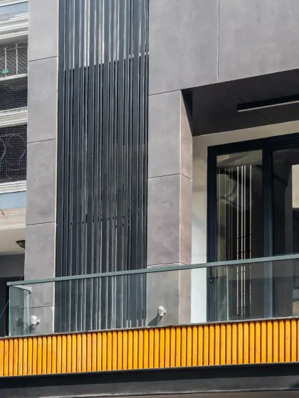Bold lines and warm finishes define this modern elevation. C-channel frames provide structure, while wood-finish aluminum fluted panels bring a touch of nature and dynamic balance to the facade.
