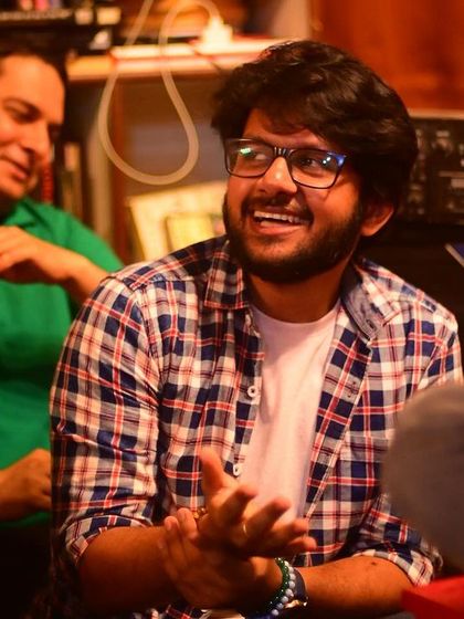 A candid shot of a musician enjoying the vibe at our "Rhyme and Rhythm" open mic, surrounded by an appreciative audience.