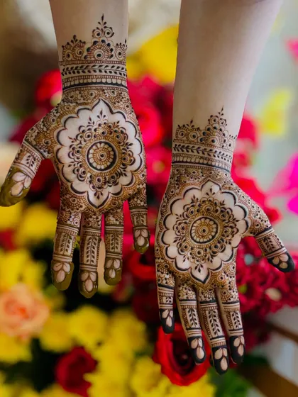 This intricate mandala design is a popular choice for bridesmaids and close family. The bold central flower is complemented by detailed work on the fingers and a delicate wristband, creating a balanced and beautiful look.