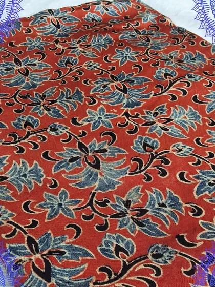 A rich red Ajrakh printed fabric with a beautiful floral jaal design. The intricate patterns and vibrant color make it a stunning choice for a custom outfit.