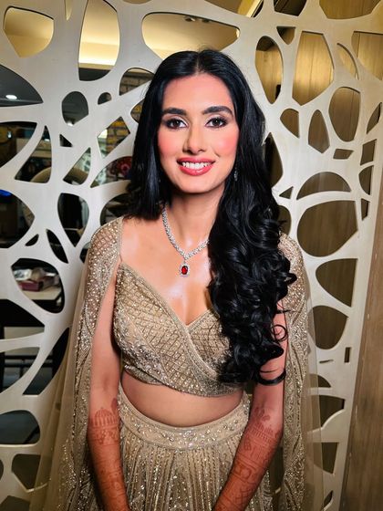 A happy and confident bride-to-be. Her engagement look features striking glittery eyes and glowing skin, paired with a bright, joyful smile.