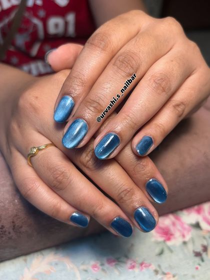 A mesmerizing blue cat-eye effect on short, natural-looking nails. The magnetic polish creates a deep, ocean-like shimmer that is both mysterious and beautiful.